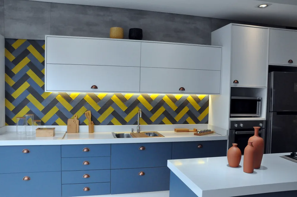 Cozinha planejada com marcenaria azul e revestimento amarelo
