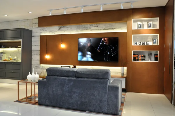 Living com painel de TV, nichos iluminados e prateleiras